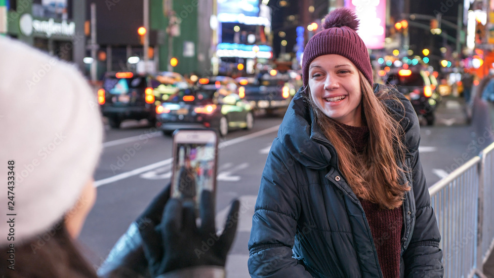 Two girls in New York take photos at Times Square Two girls in New York take photos at Times Square