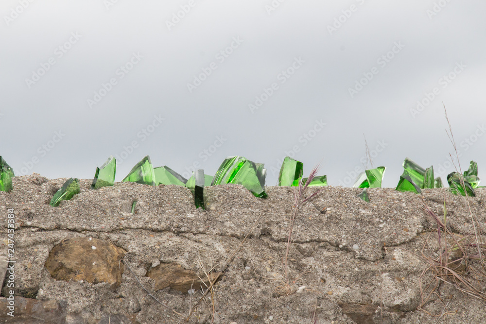Broken glass on top of an ancient wall. Broken glass on top of an ancient wall.