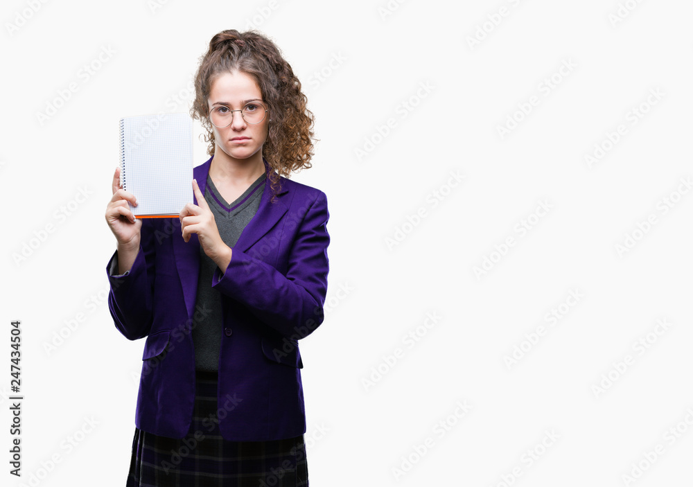 Young brunette student girl wearing school uniform holding a notebook over isolated background with a confident expression on smart face thinking serious Young brunette student girl wearing school uniform holding a notebook over isolated background with a confident expression on smart face thinking serious