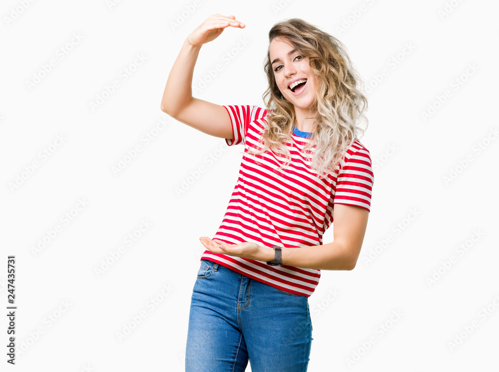 Beautiful young blonde woman over isolated background gesturing with hands showing big and large size sign, measure symbol. Smiling looking at the camera. Measuring concept. Beautiful young blonde woman over isolated background gesturing with hands showing big and large size sign, measure symbol. Smiling looking at the camera. Measuring concept.