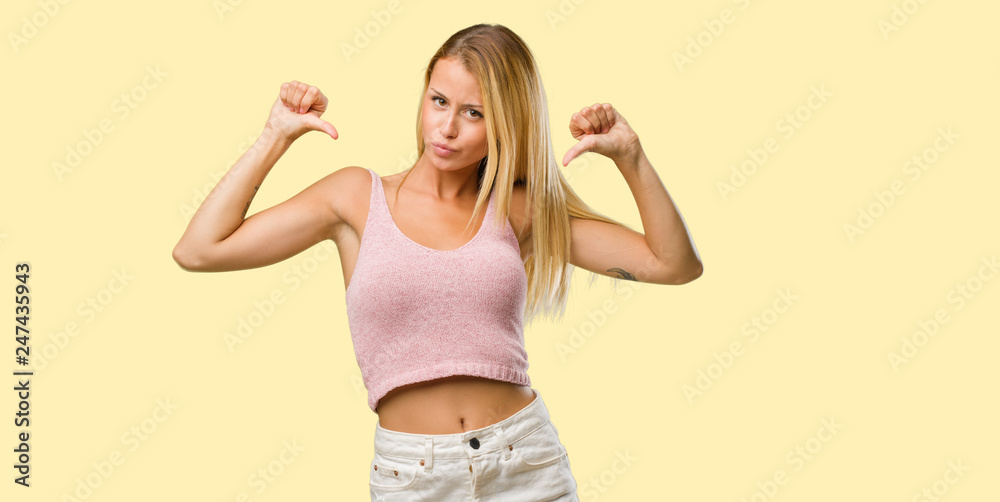 Portrait of young pretty blonde woman proud and confident, pointing fingers, example to follow, concept of satisfaction, arrogance and health Portrait of young pretty blonde woman proud and confident, pointing fingers, example to follow, concept of satisfaction, arrogance and health