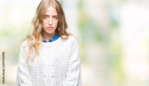 Beautiful young blonde woman wearing winter sweater over isolated background depressed and worry for distress, crying angry and afraid. Sad expression.
