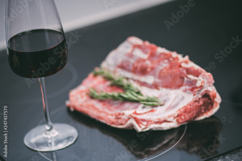 Raw pork ribs with a glass of red wine
