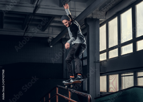 Skateboarder performing a trick on mini ramp at skate park indoor.