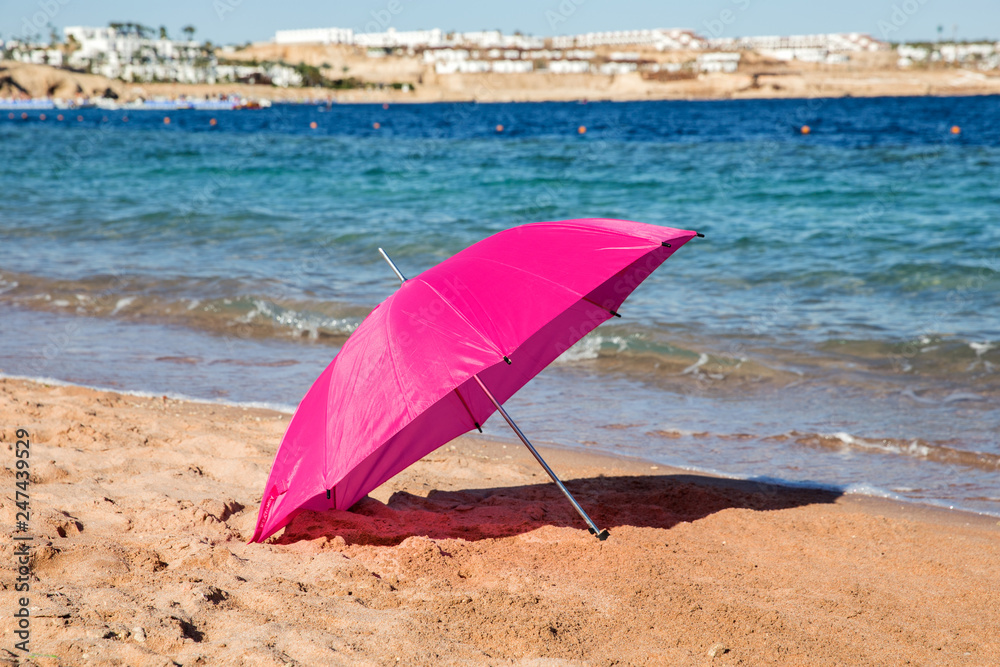 Umbrella on a sandy beach, summertime