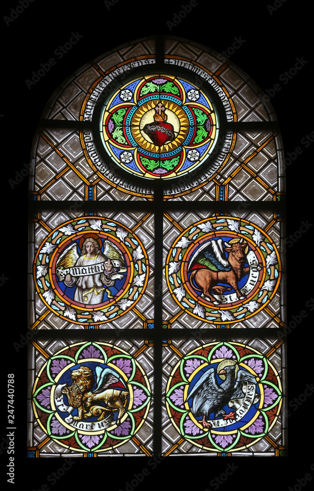 Symbols of the Evangelists, stained glass window in the parish church of St. Peter and Paul in Oberstaufen, Germany Symbols of the Evangelists, stained glass window in the parish church of St. Peter and Paul in Oberstaufen, Germany