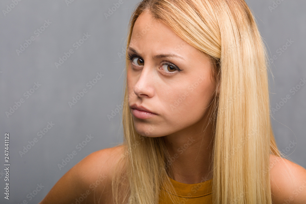 Fototapeta premium Zbliżenie twarzy, portret naturalnej młodej blondynki kobiety bardzo zły i zdenerwowany, bardzo napięty, krzyczący wściekły, negatywny i szalony