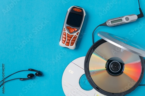 personal cd player with remote control and mobile phone on blue background