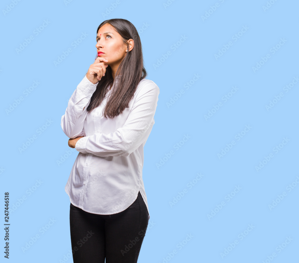 Portrait of a young indian woman doubting and confused, thinking of an idea or worried about something Portrait of a young indian woman doubting and confused, thinking of an idea or worried about something