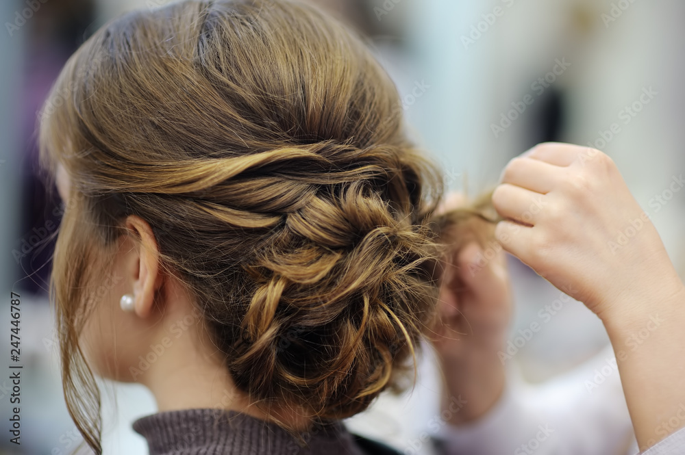 Naklejka premium Young woman/bride getting her hair done before wedding or party