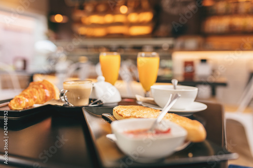 Closeup of a delicious breakfast, it includes orange juice, toast bread and a croissant, coffee and tea. © Asier