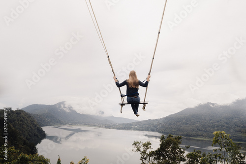 girl on a swing flies over a valley with lakes