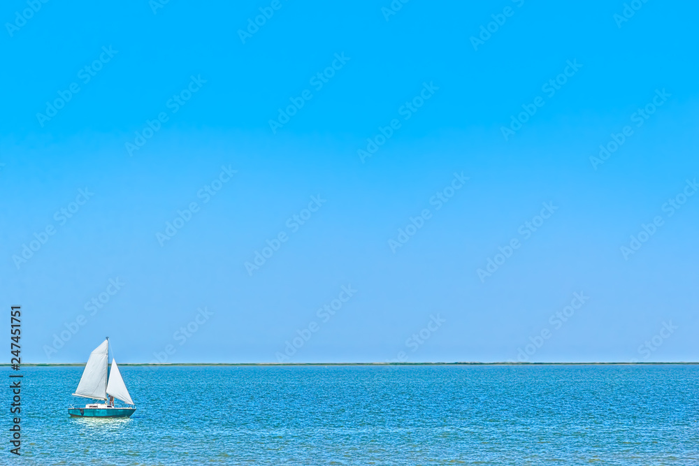 Obraz premium Sailboat in the blue sea on a sunny summer day