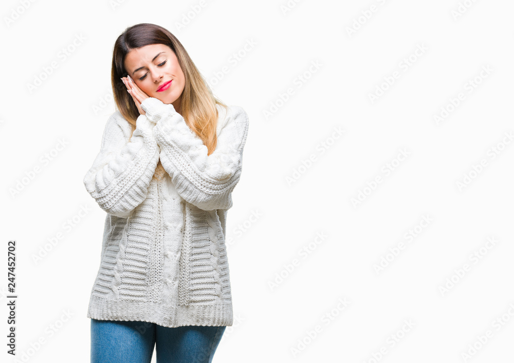 Young beautiful woman casual white sweater over isolated background sleeping tired dreaming and posing with hands together while smiling with closed eyes. Young beautiful woman casual white sweater over isolated background sleeping tired dreaming and posing with hands together while smiling with closed eyes.