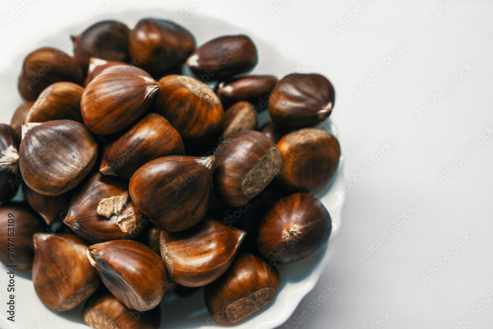 Chestnuts on a blank (white) background. Pile of fresh chestnuts ready to roast shot over white background Chestnuts on a blank (white) background. Pile of fresh chestnuts ready to roast shot over white background