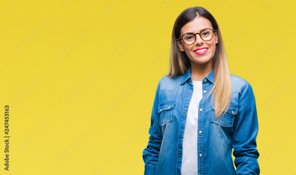 Young beautiful woman over wearing glasses over isolated background with a happy and cool smile on face. Lucky person.