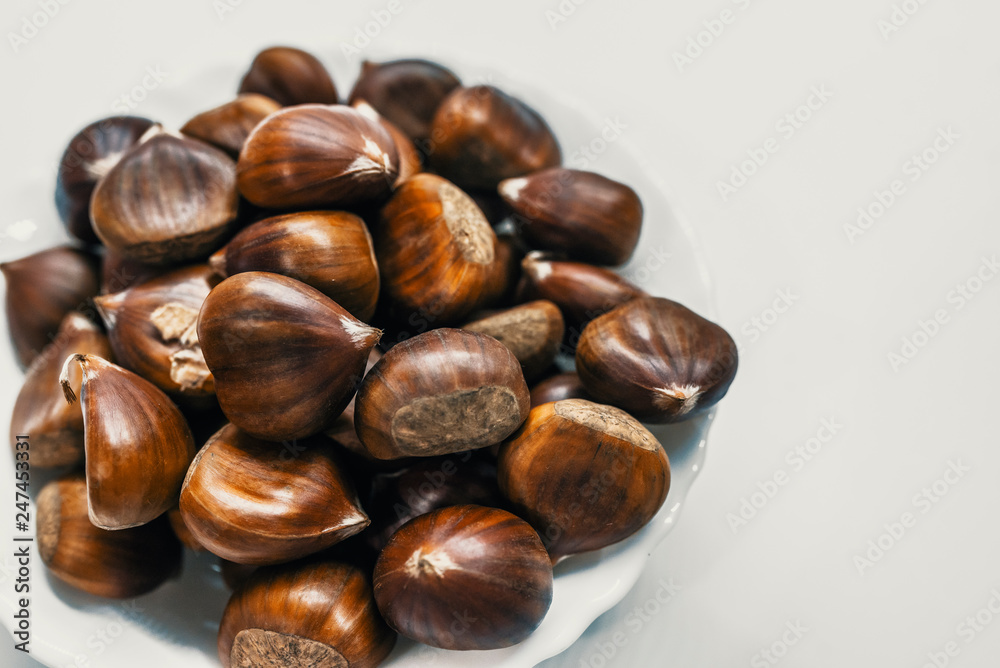 Chestnuts on a blank (white) background. Pile of fresh chestnuts ready to roast shot over white background Chestnuts on a blank (white) background. Pile of fresh chestnuts ready to roast shot over white background