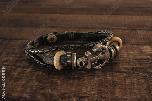 bracelet with an anchor sign. anchor lying on a wooden background