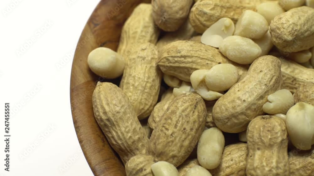 Peanuts. Mixed Peanuts in rotation. Snack closeup. Peanuts in a bowl. Selective focus. Isolated on white. Studio shot. Healthy food concept. Peanuts. Mixed Peanuts in rotation. Snack closeup. Peanuts in a bowl. Selective focus. Isolated on white. Studio shot. Healthy food concept.