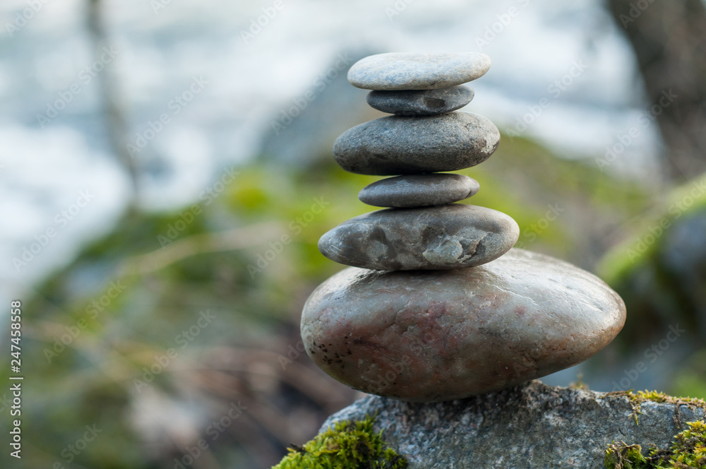 Closeup of stone balance on rock in border river Closeup of stone balance on rock in border river