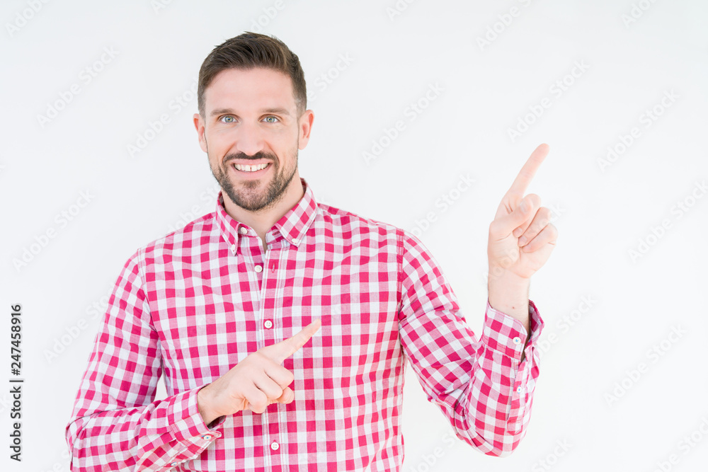Young handsome man wearing shirt over isolated background smiling and looking at the camera pointing with two hands and fingers to the side. Young handsome man wearing shirt over isolated background smiling and looking at the camera pointing with two hands and fingers to the side.