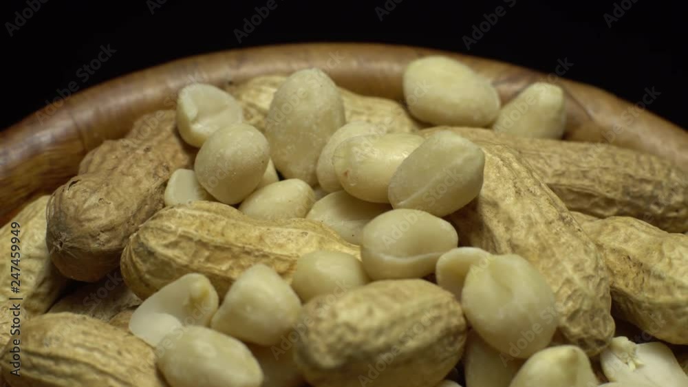 Peanuts. Mixed Peanuts in rotation. Snack closeup. Peanuts in a bowl. Selective focus. black background. Studio shot. Healthy food concept. Peanuts. Mixed Peanuts in rotation. Snack closeup. Peanuts in a bowl. Selective focus. black background. Studio shot. Healthy food concept.