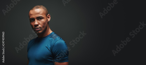 To change your body you must first change your mind. Handsome sportsman standing over dark background