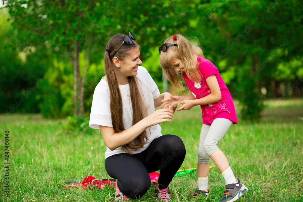 Mother and little daughter playing together in park. Outdoor Portrait of happy family. Happy Mother's Day Joy. Mom and Baby