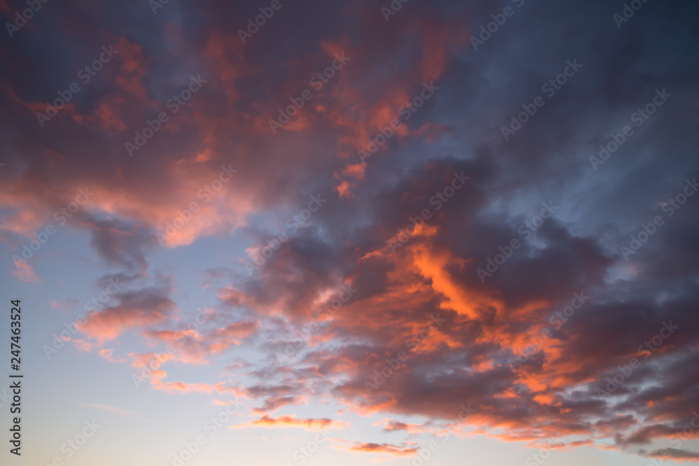 Blue sky with orange and dark clouds, background