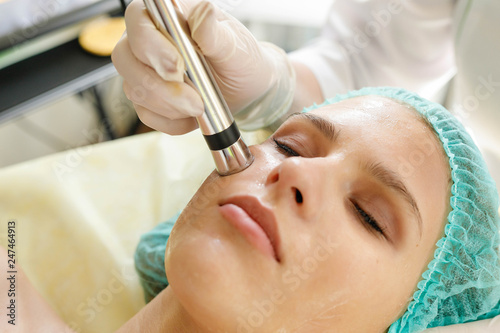 Cosmetologist makes the procedure microcurrent therapy beauty salon