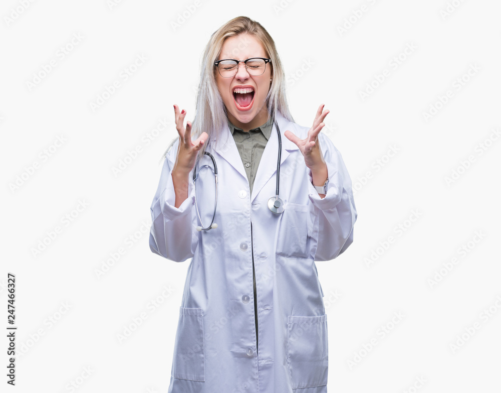 Young blonde doctor woman over isolated background celebrating mad and crazy for success with arms raised and closed eyes screaming excited. Winner concept