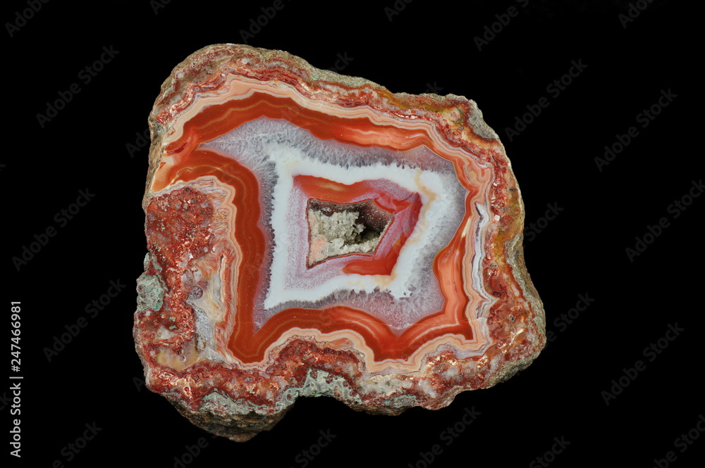 A cross section of the agate. Red shades in the outer part. In the center gray, transparent quartz. Chalcedony lamination occurs in some places. Origin: Agouin, Atlas mountains, Morocco. A cross section of the agate. Red shades in the outer part. In the center gray, transparent quartz. Chalcedony lamination occurs in some places. Origin: Agouin, Atlas mountains, Morocco.