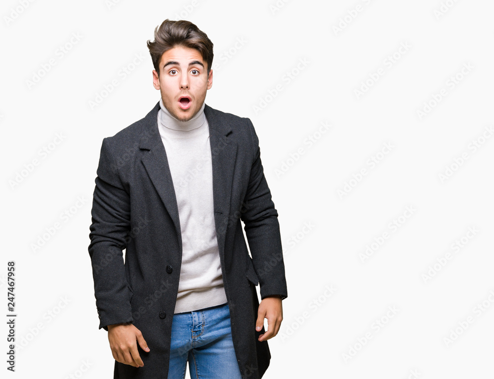 Young elegant man wearing winter coat over isolated background afraid and shocked with surprise expression, fear and excited face. Young elegant man wearing winter coat over isolated background afraid and shocked with surprise expression, fear and excited face.