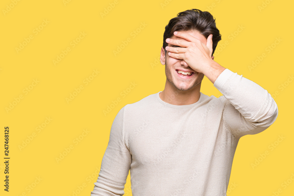 Young handsome man over isolated background smiling and laughing with hand on face covering eyes for surprise. Blind concept. Young handsome man over isolated background smiling and laughing with hand on face covering eyes for surprise. Blind concept.