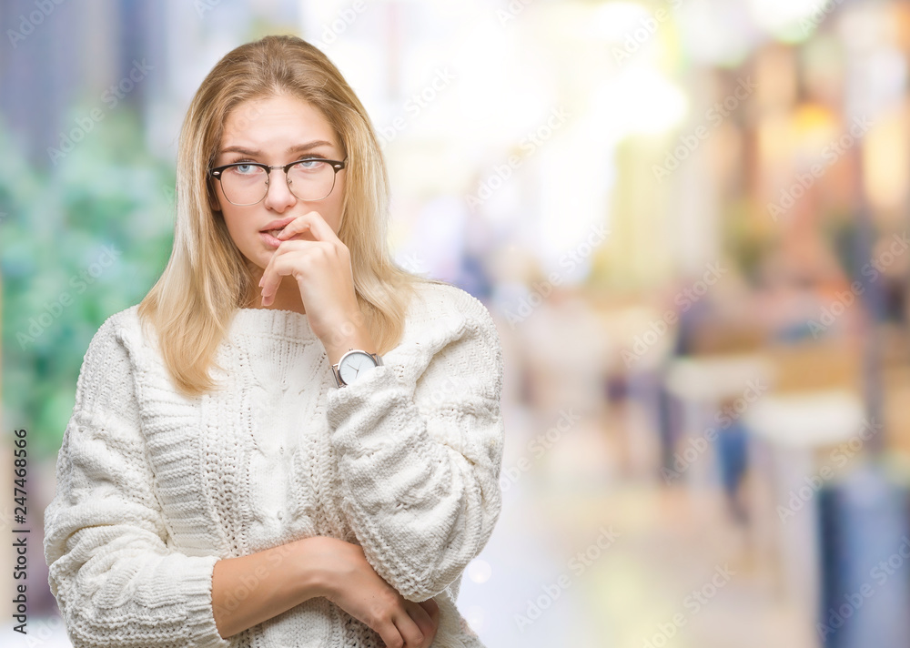 Young caucasian woman over isolated background with hand on chin thinking about question, pensive expression. Smiling with thoughtful face.