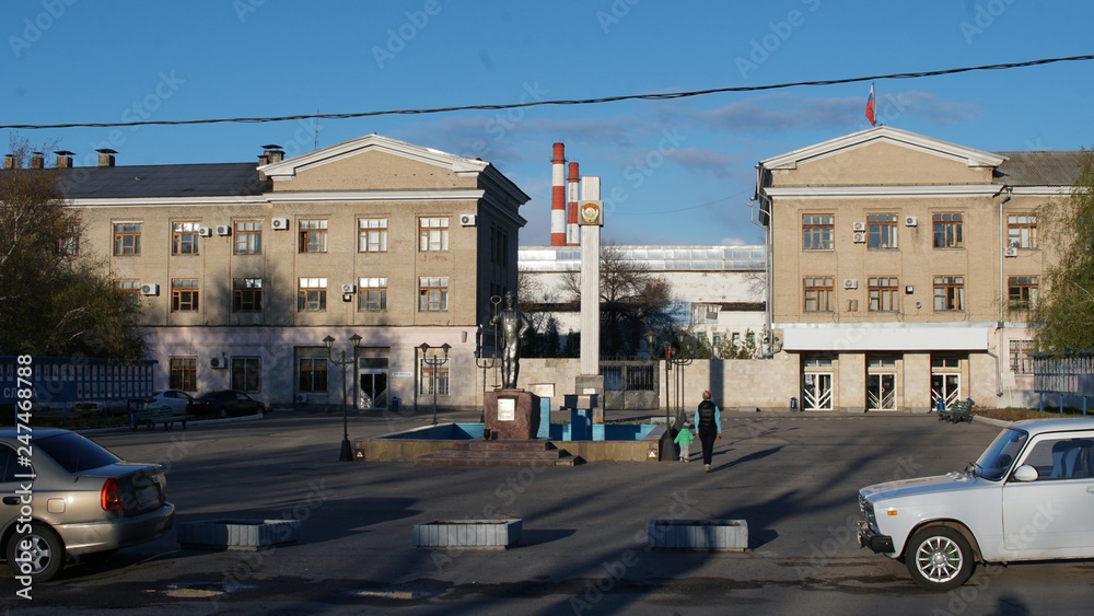 Old town. Urban metallurgical plant with statue of the metallurgist