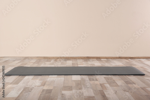 Grey yoga mat on floor indoors. Space for text