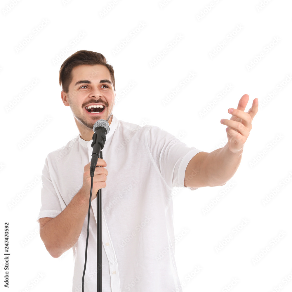 Young handsome man singing in microphone on white background
