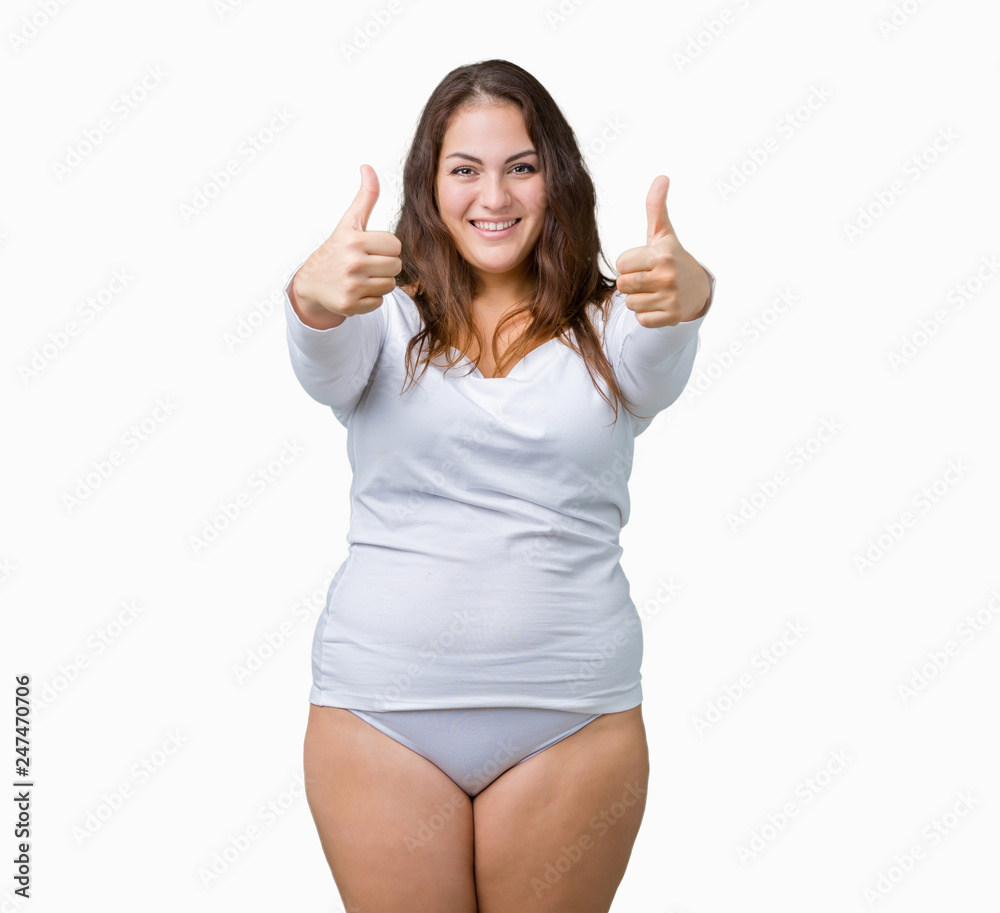 Beautiful plus size young overwight woman wearing white underwear over isolated background doing happy thumbs up gesture with hand. Approving expression looking at the camera showing success. Beautiful plus size young overwight woman wearing white underwear over isolated background doing happy thumbs up gesture with hand. Approving expression looking at the camera showing success.