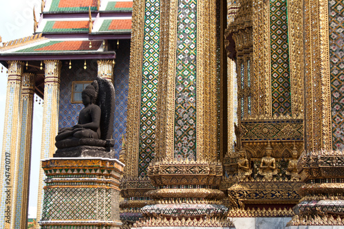Black buddha statue and columns pattern detail in Wat Phra Kaew temple within Grand Palace complex in Bangkok, Thailand