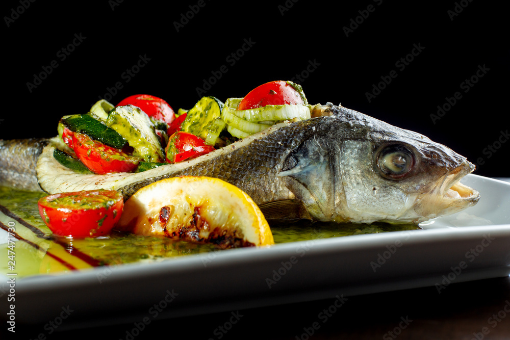 Baked, stuffed fish. Filling of salted cucumbers, tomatoes and onions.