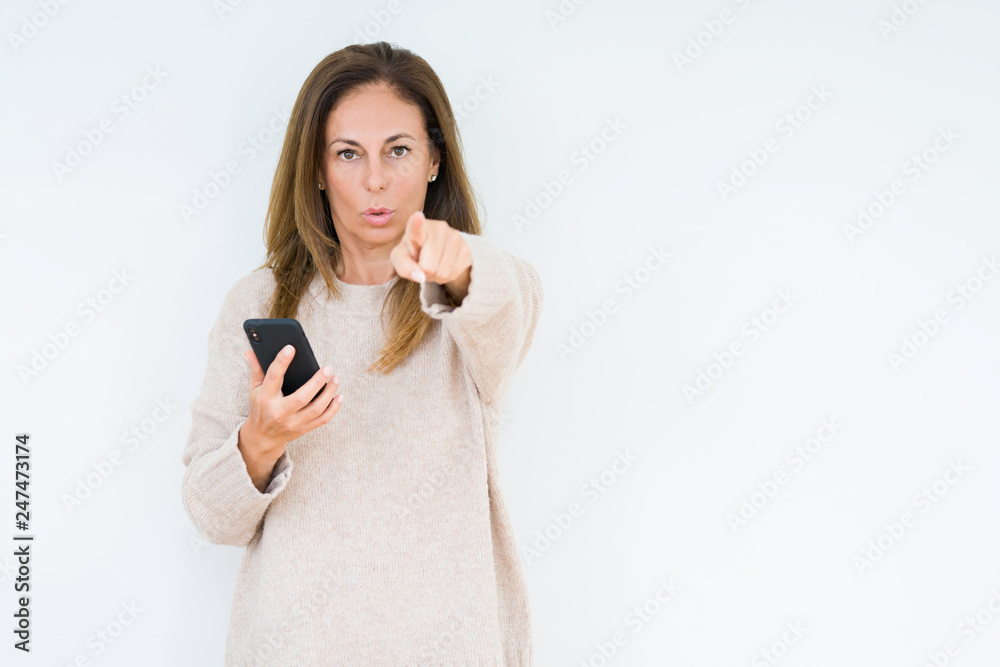 Middle age woman using smartphone over isolated background pointing with finger to the camera and to you, hand sign, positive and confident gesture from the front Middle age woman using smartphone over isolated background pointing with finger to the camera and to you, hand sign, positive and confident gesture from the front