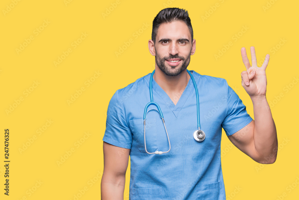 Handsome young doctor surgeon man over isolated background showing and pointing up with fingers number three while smiling confident and happy. Handsome young doctor surgeon man over isolated background showing and pointing up with fingers number three while smiling confident and happy.