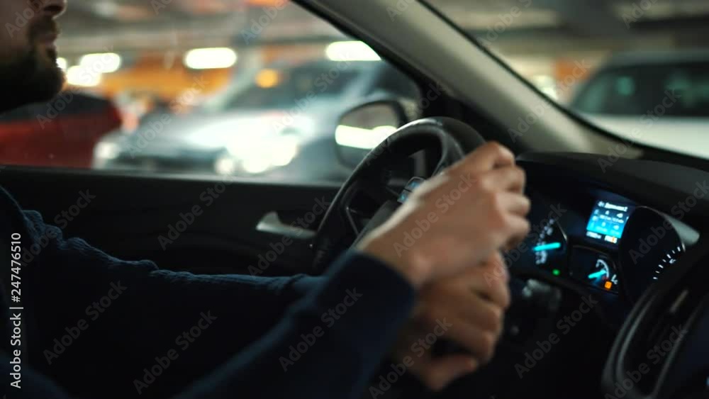 Man is driving through a parking lot and is looking for a place to park Man is driving through a parking lot and is looking for a place to park