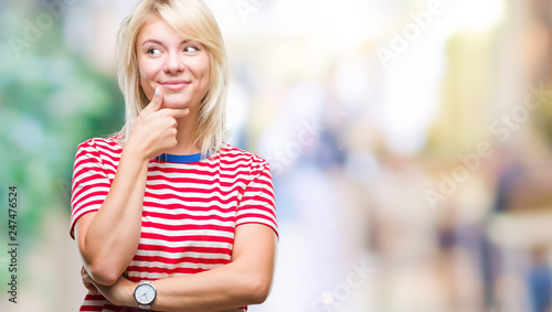 Young beautiful blonde woman over isolated background with hand on chin thinking about question, pensive expression. Smiling with thoughtful face. Doubt concept.