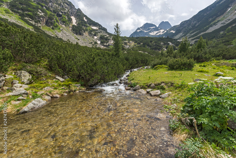 Landscape with dark clouds over Malyovitsa peak and Malyoviska river, Rila Mountain, Bulgaria