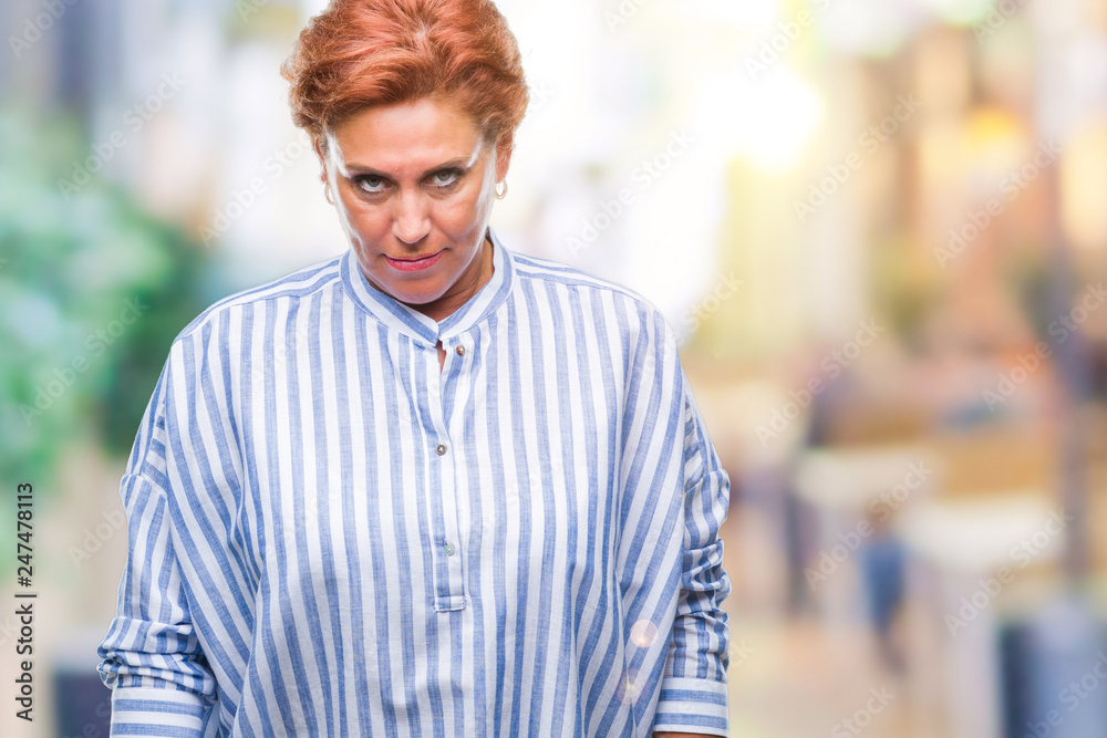 Atrractive senior caucasian redhead woman over isolated background skeptic and nervous, frowning upset because of problem. Negative person. Atrractive senior caucasian redhead woman over isolated background skeptic and nervous, frowning upset because of problem. Negative person.