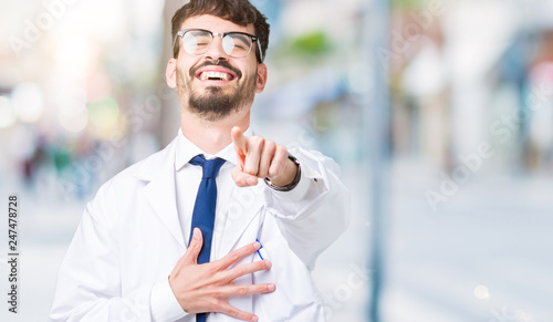 Young professional scientist man wearing white coat over isolated background Laughing of you, pointing to the camera with finger hand over chest, shame expression