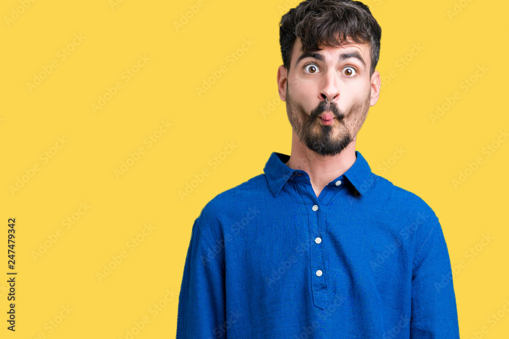 Young handsome man over isolated background making fish face with lips, crazy and comical gesture. Funny expression.