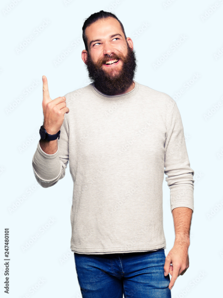 Young blond man wearing casual sweater pointing finger up with successful idea. Exited and happy. Number one. Young blond man wearing casual sweater pointing finger up with successful idea. Exited and happy. Number one.